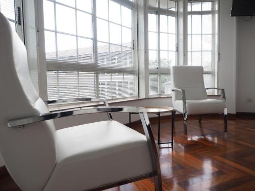 two chairs and a table in a room with windows at PR Una Estrella Dorada in O Pedrouzo