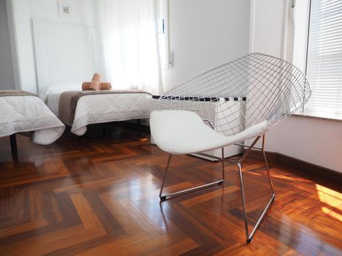a white chair sitting on a wooden floor in a room at PR Una Estrella Dorada in O Pedrouzo