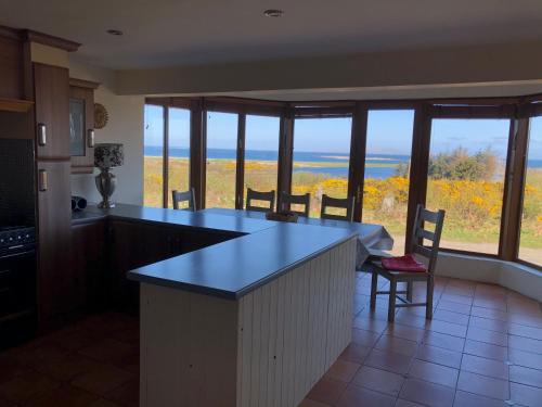 
a kitchen with a dining room table and chairs at House with sea views close to Beach with WiFi and large kitchen and dining in Ardnagreevagh
