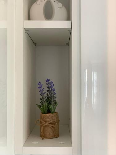 a white shelf with a vase and a plant in it at Apartments Ema in Sali