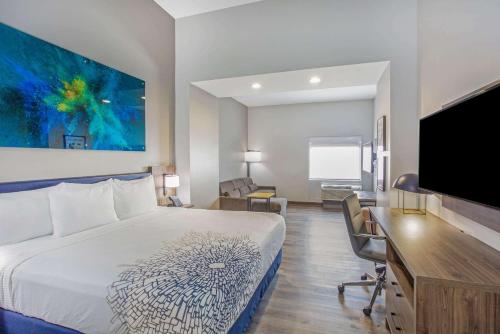 a hotel room with a bed and a desk and a tv at La Quinta Inn & Suites by Wyndham Miramar Beach-Destin in Destin