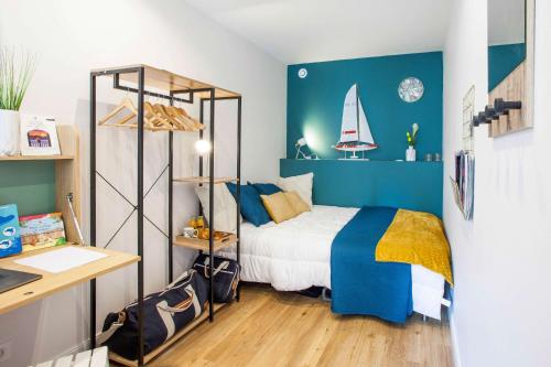 a small bedroom with a bed and a desk at Homard and Fox, Appartement 2 chambres 100m de la mer in Dinard