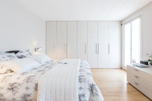 a white bedroom with a bed and a dresser at Villa Cosy Spa - Strasbourg in Mundolsheim