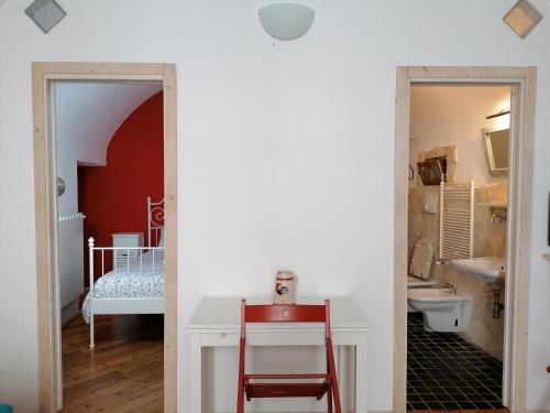 a room with a white desk and a red chair at Dimora di Ponente in Ostuni