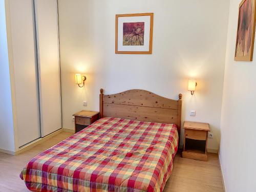 um pequeno quarto com uma cama e duas mesas de cabeceira em Appartement 107 Résidence du Grand Hotel Aulus-les-Bains em Aulus-les-Bains
