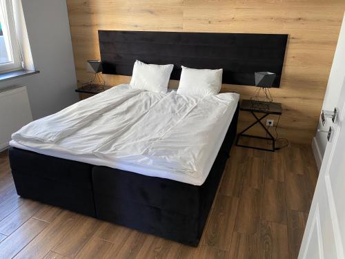 duże łóżko z białą pościelą i poduszkami w obiekcie Domek Maris w mieście Międzyzdroje