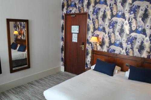 a hotel room with a bed and a mirror at Best Western de Diane in Nevers