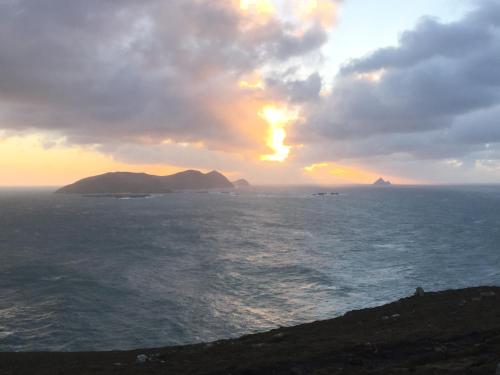 a sunset over the ocean with islands in the distance at Ard na Carraige, Ventry Holiday Home in Dingle