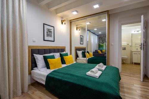 a bedroom with a bed with yellow and green pillows at PIWNICZKA - Pokoje Zakopane Centrum in Zakopane