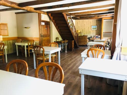 un restaurant avec des tables et des chaises et un escalier dans l'établissement Logis Hôtel-restaurant Les Coudercous, à Saint-Chély-dʼAubrac