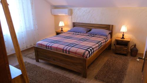 a bedroom with a bed with two night stands and two lamps at Country House Djurisic in Virpazar