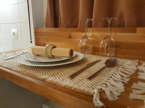 - une table avec une assiette et deux verres à vin dans l'établissement Paris Lady Mimi, à Paris