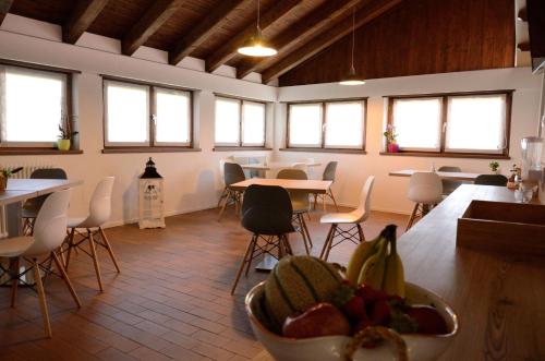a room with tables and chairs and a bowl of fruit at Al Trifoglio in Campodenno