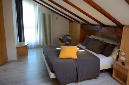 a bedroom with a bed with a yellow pillow on it at Al Trifoglio in Campodenno