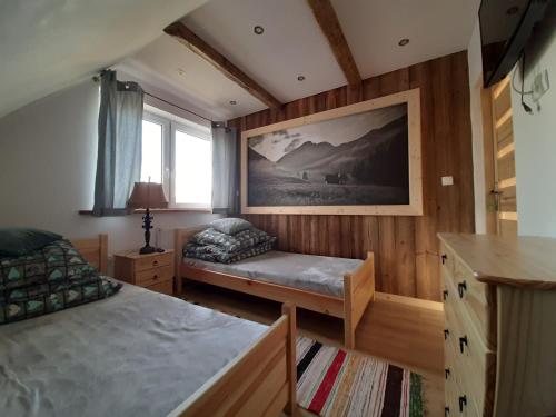 a bedroom with two beds and a window at Domek u Andrzeja in Ciche