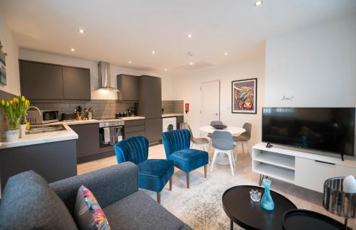 a living room with a couch and chairs and a kitchen at Charles Alexander Short Stay - Windmill House Apartments in Lytham St Annes