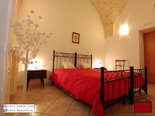 um quarto com uma cama com uma colcha vermelha em Stars House em Locorotondo
