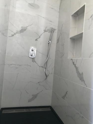 La salle de bains est pourvue d'une douche et d'un mur en marbre. dans l'établissement La loge 45 AU COEUR DU CENTRE HISTORIQUE DE RODEZ, à Rodez