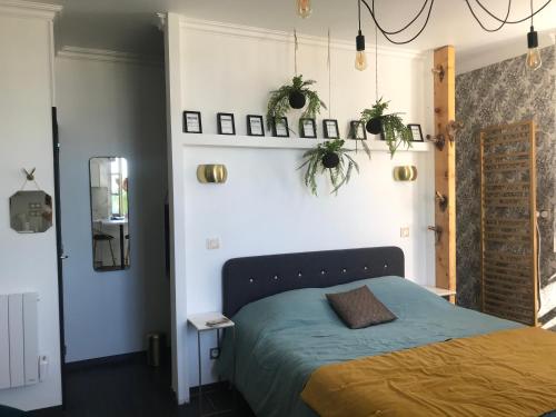 - une chambre avec un lit et des plantes sur le mur dans l'établissement La loge 45 AU COEUR DU CENTRE HISTORIQUE DE RODEZ, à Rodez