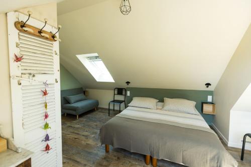 une chambre avec un lit et une chaise dans l'établissement La maison de Jean, à Milizac