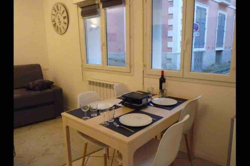 une salle à manger avec une table avec des chaises et une bouteille de vin dans l'établissement Centre Cauterets grand T2 entièrement rénové, à Cauterets