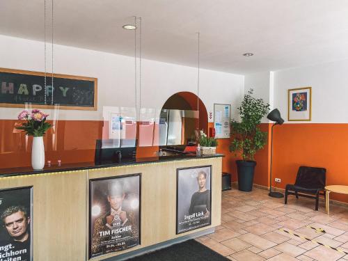 a lobby with a counter with posters on it at Happy Hotel Berlin in Berlin