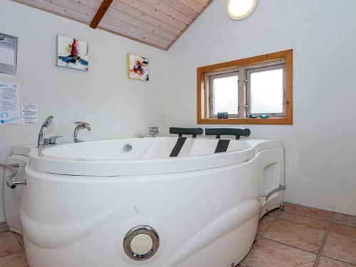 a white bath tub in a bathroom with a window at Three-Bedroom Holiday home in Hemmet 26 in Hemmet