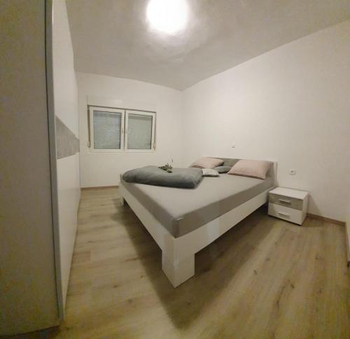 a bedroom with a bed and a wooden floor at Apartman Školj in Jovići
