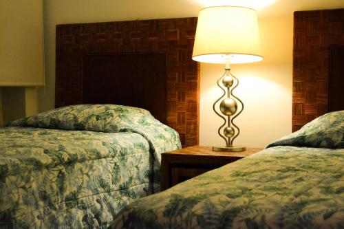 pokój hotelowy z 2 łóżkami i lampą w obiekcie Playasol Las Hadas w mieście Manzanillo