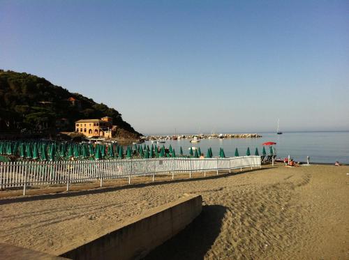 a beach with a fence and umbrellas and the water at Dolcevia in Levanto