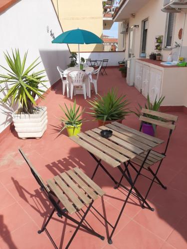 un patio con mesa, sillas y sombrilla en Allegra B&B, en Terracina