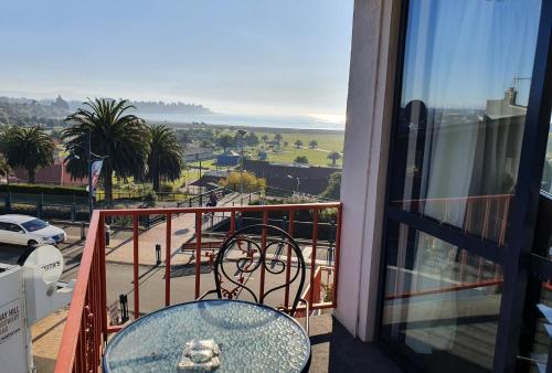 a table on a balcony with a view of the ocean at Panorama Motor Lodge in Timaru
