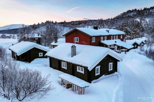 a village covered in snow with a red house at Rondane River Lodge - Rondane Gjestegård in Enden