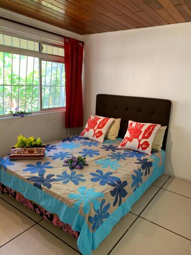 Un dormitorio con una cama con flores azules. en Wendy Location, en Papeete