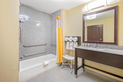 a bathroom with a tub and a sink and a shower at La Quinta by Wyndham Elk City in Elk City