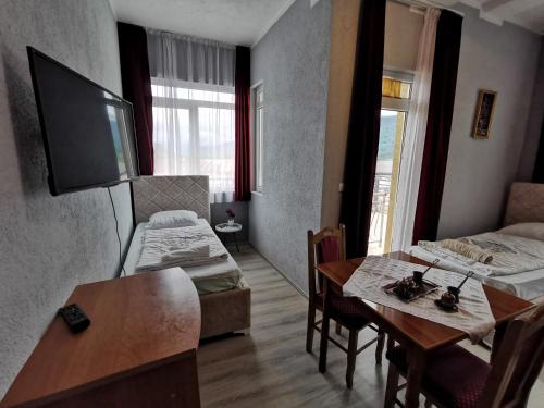 a room with two beds and a table with a dining room at Hotel Rosi in Gusinje
