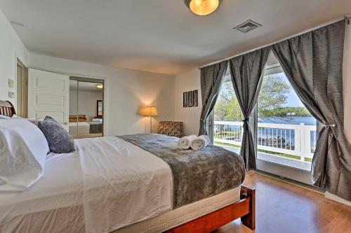 1 dormitorio con cama y ventana grande en Luxe Lakefront Family Cottage Private Beach, Dock en Bethel
