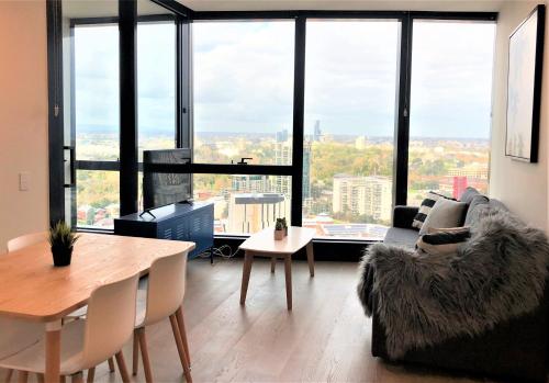 a living room with a table and a large window at ReadySet Apartments on Southbank Boulevard in Melbourne