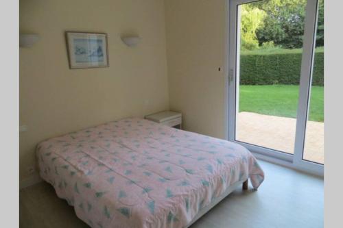 a bedroom with a bed and a sliding glass door at Beg Meil in Fouesnant