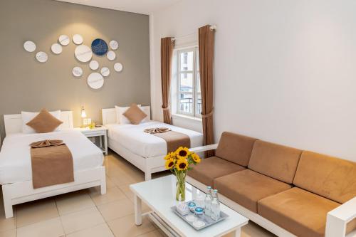 a living room with two beds and a couch at Alba Hotel in Hue