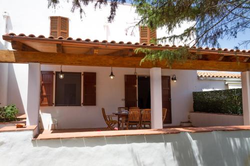 a house with a patio with a table and chairs at Guest House Pimpioxelli Tonnare in Carloforte