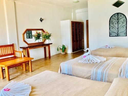 Cette chambre d'hôtel comprend 2 lits et un lit de cygne. dans l'établissement Hotel Cordelia's, à Puerto Ángel