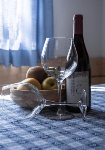 a wine glass sitting next to a bottle of wine at HAUSERHOF - Urlaub auf dem Bauernhof in Villandro