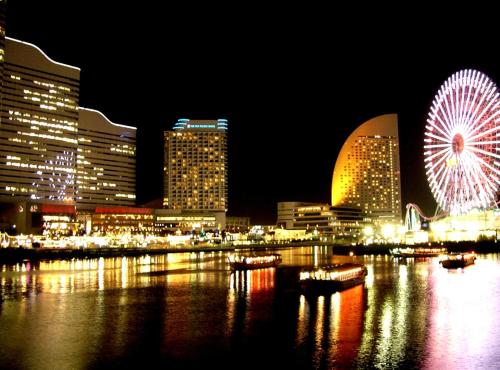 a city at night with a ferris wheel and buildings at Sotetsu Fresa Inn Yokohama Higashiguchi in Yokohama