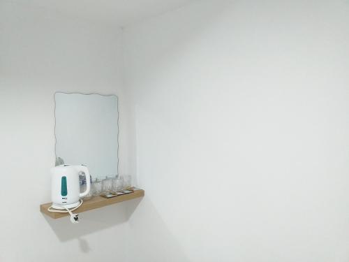 un espejo en un estante en una pared blanca en Orange Villa Hotel Near Palm Mall Seremban en Seremban