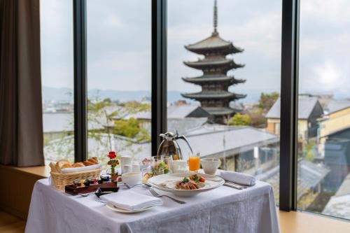 a table with plates of food and a view of a building at The Hotel Seiryu Kyoto Kiyomizu - a member of the Leading Hotels of the World- in Kyoto