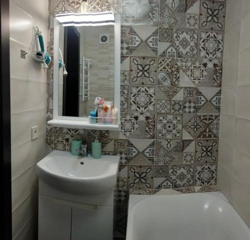 ein Badezimmer mit einem Waschbecken, einem WC und einem Spiegel in der Unterkunft АpartmentAnna in Odessa
