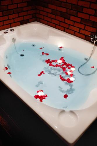 a bath tub filled with red hearts floating in it at THE CRYSTAL BLUE XAIDARI HOTEL in Skaramangás