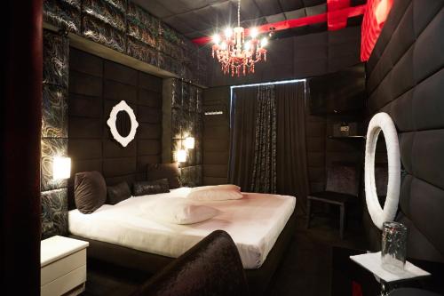 a bedroom with a large bed and a chandelier at THE CRYSTAL BLUE XAIDARI HOTEL in Skaramangás