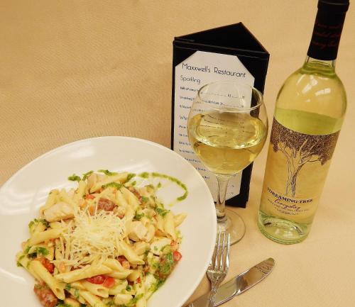 a plate of pasta next to a bottle of wine at The Campbell Hotel in Tulsa